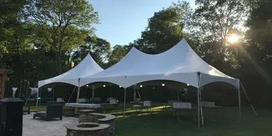 A large white tent is sitting on top of a lush green field.