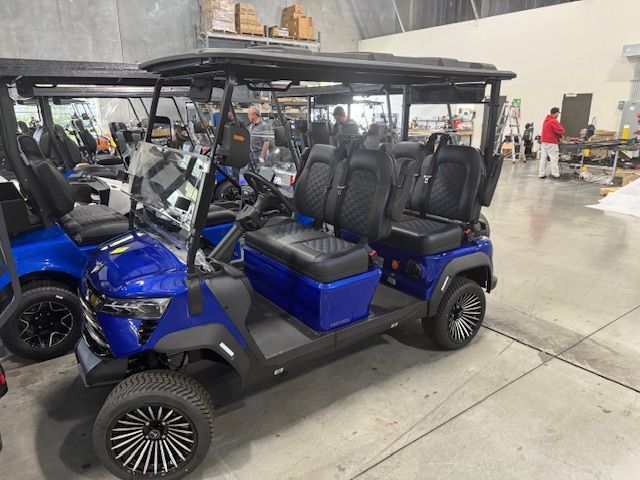 Red golf cart with black roof, chrome accents, and large wheels in an indoor setting.