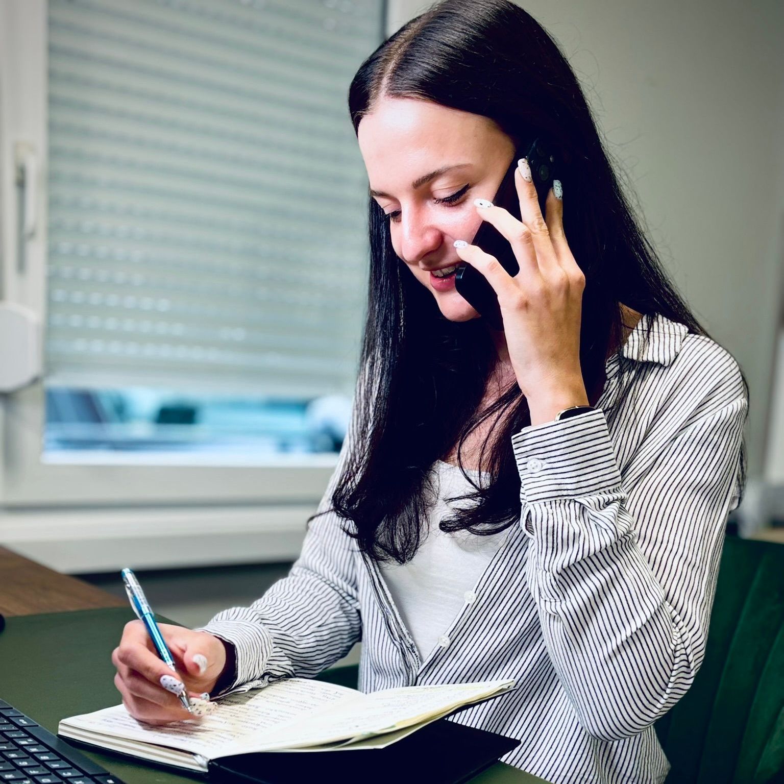Eine Frau sitzt in Jeans und mit einer Uhr auf dem Boden.