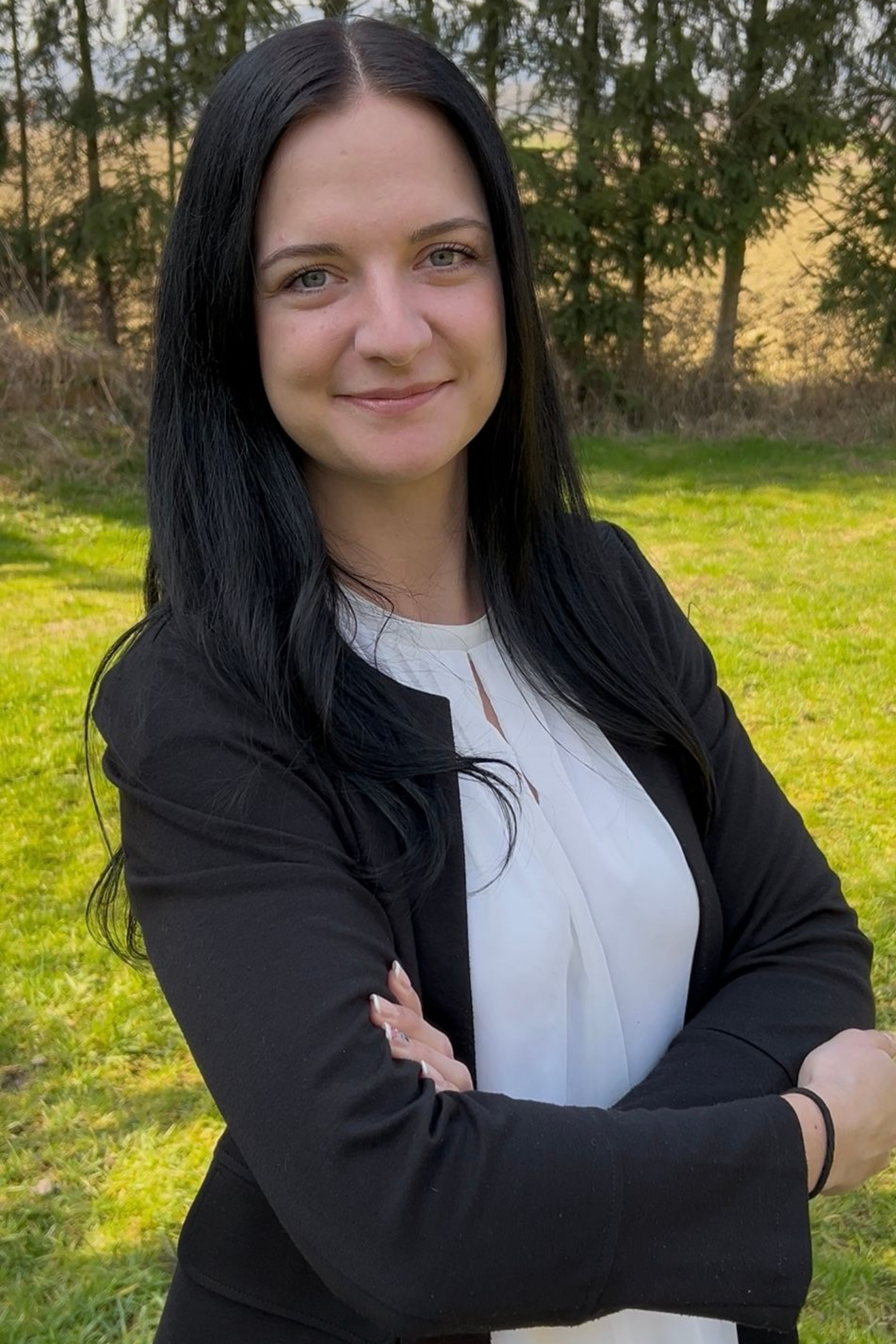 Eine Frau sitzt in Jeans und mit einer Uhr auf dem Boden.