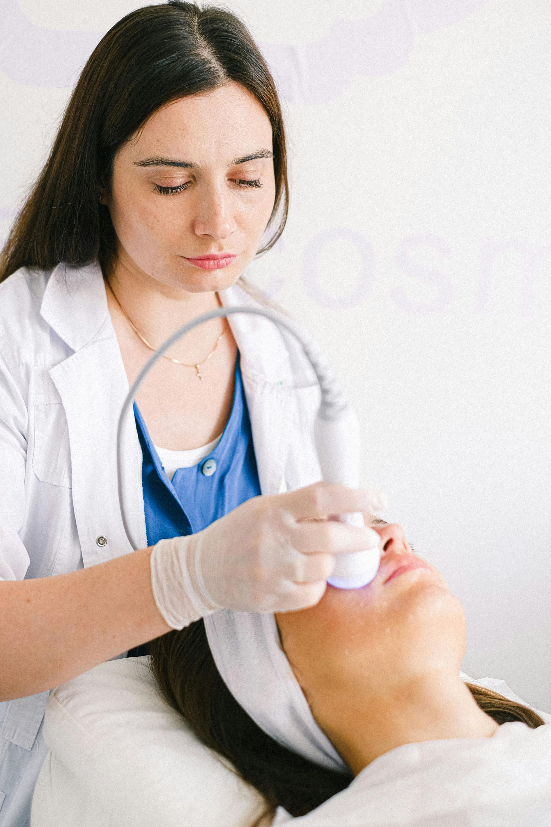 A woman is getting a facial treatment from a doctor.