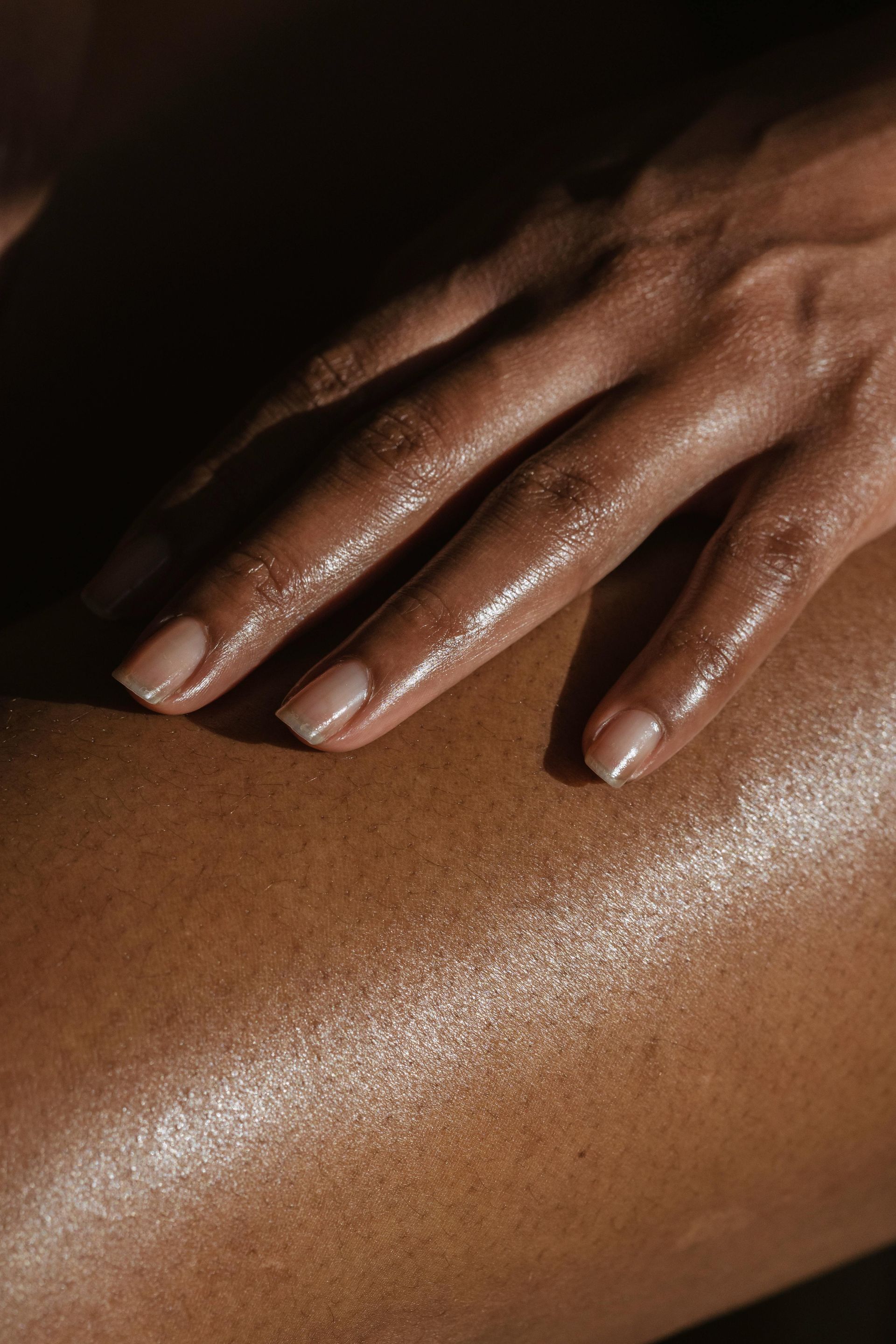 A close up of a person 's hand on another person 's leg.