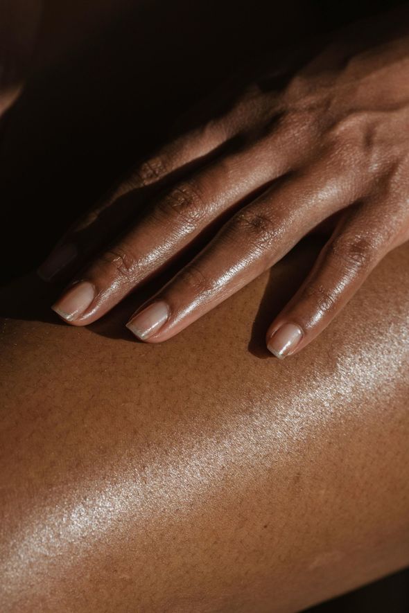 A close up of a person 's hand on another person 's leg.