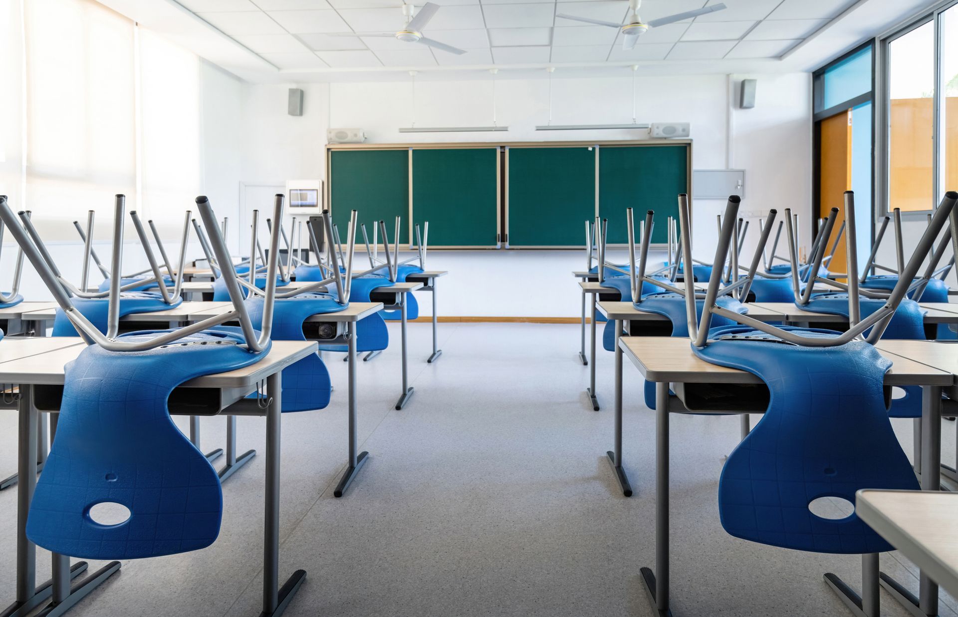 Un'aula vuota con sedie e tavoli blu