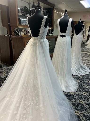 A row of wedding dresses on mannequins in a store.