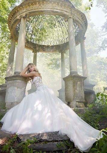 A woman in a wedding dress is standing in front of a gazebo.