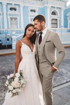 A bride and groom are posing for a picture in front of a building - Salina, KS - Princess & Penguin Formalwear