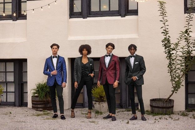 A group of people in tuxedos are standing in front of a building - Salina, KS - Princess & Penguin Formalwear