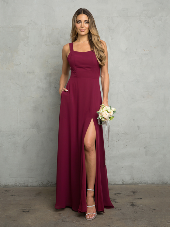 A woman is wearing a burgundy bridesmaid dress and holding a bouquet of flowers - Salina, KS - Princess & Penguin Formalwear