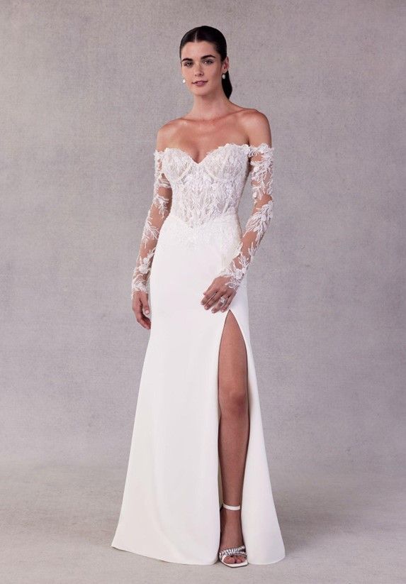 A woman is wearing a white wedding dress with long sleeves and a high slit - Salina, KS - Princess & Penguin Formalwear