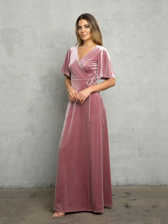 A woman is wearing a pink velvet wrap dress with short sleeves - Salina, KS - Princess & Penguin Formalwear