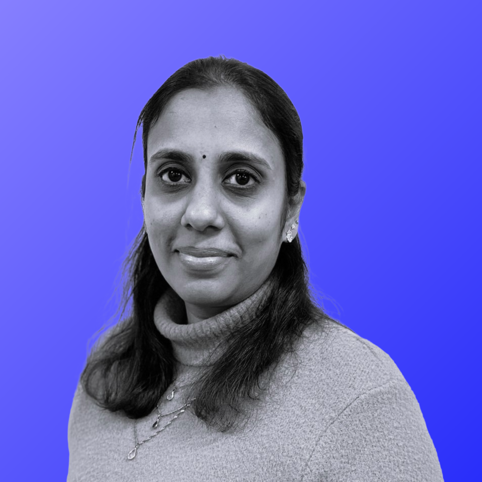 A woman is standing in front of a blue background.