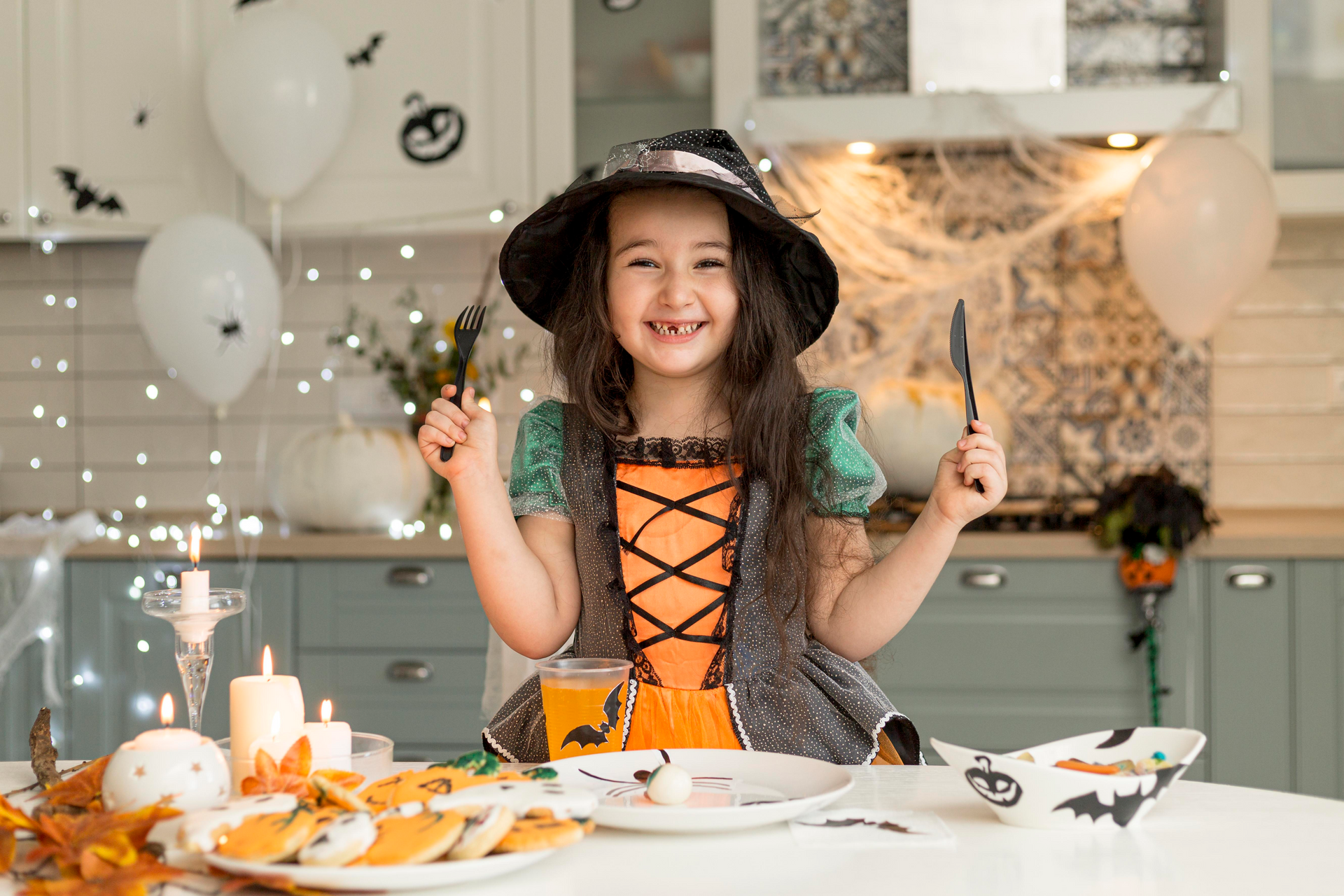 A kid in a costume excitedly waiting for her Halloween meal and sweet treats.