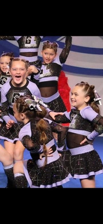 A group of cheerleaders are dancing together on a stage.