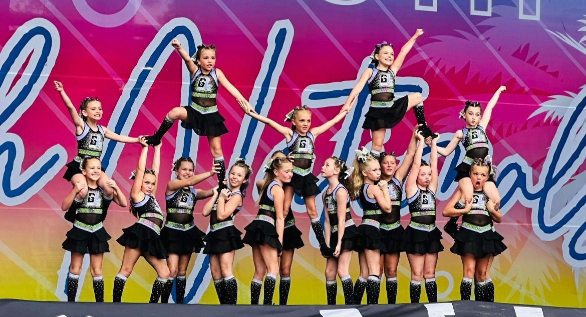 A group of cheerleaders are performing on a stage.
