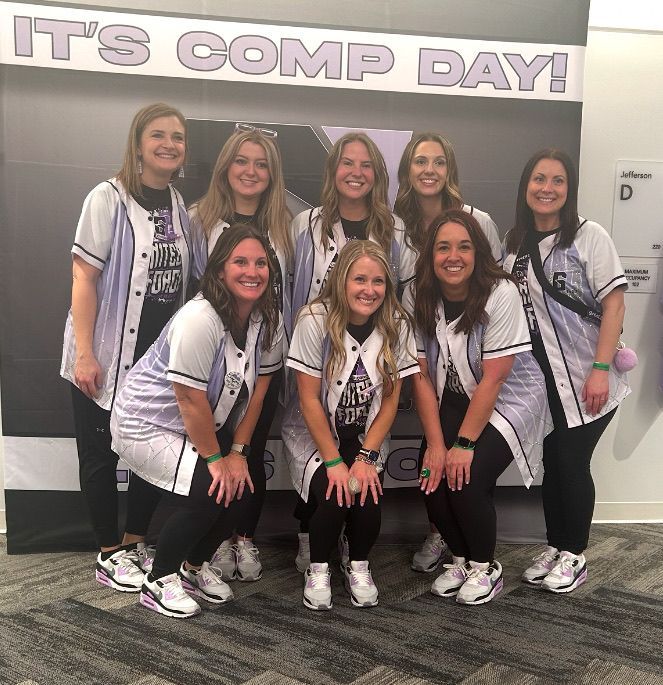 A group of women are posing for a picture in front of a sign that says it 's comp day