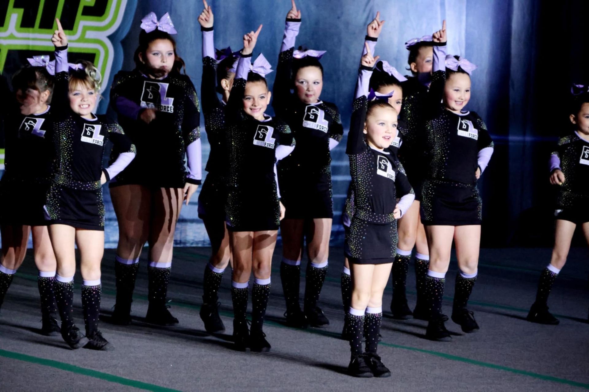 A group of cheerleaders with the letter g on their shirts