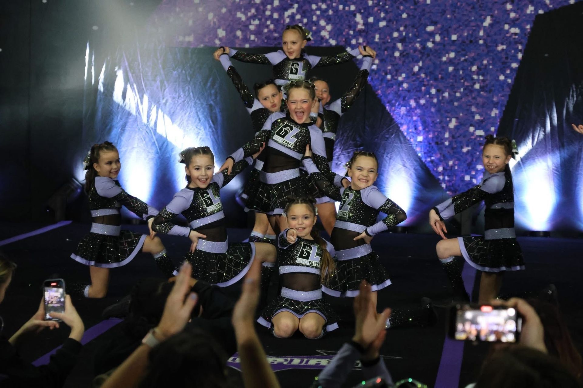 A group of cheerleaders are performing in front of a crowd.
