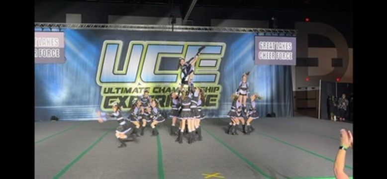 A group of cheerleaders are performing in front of a banner