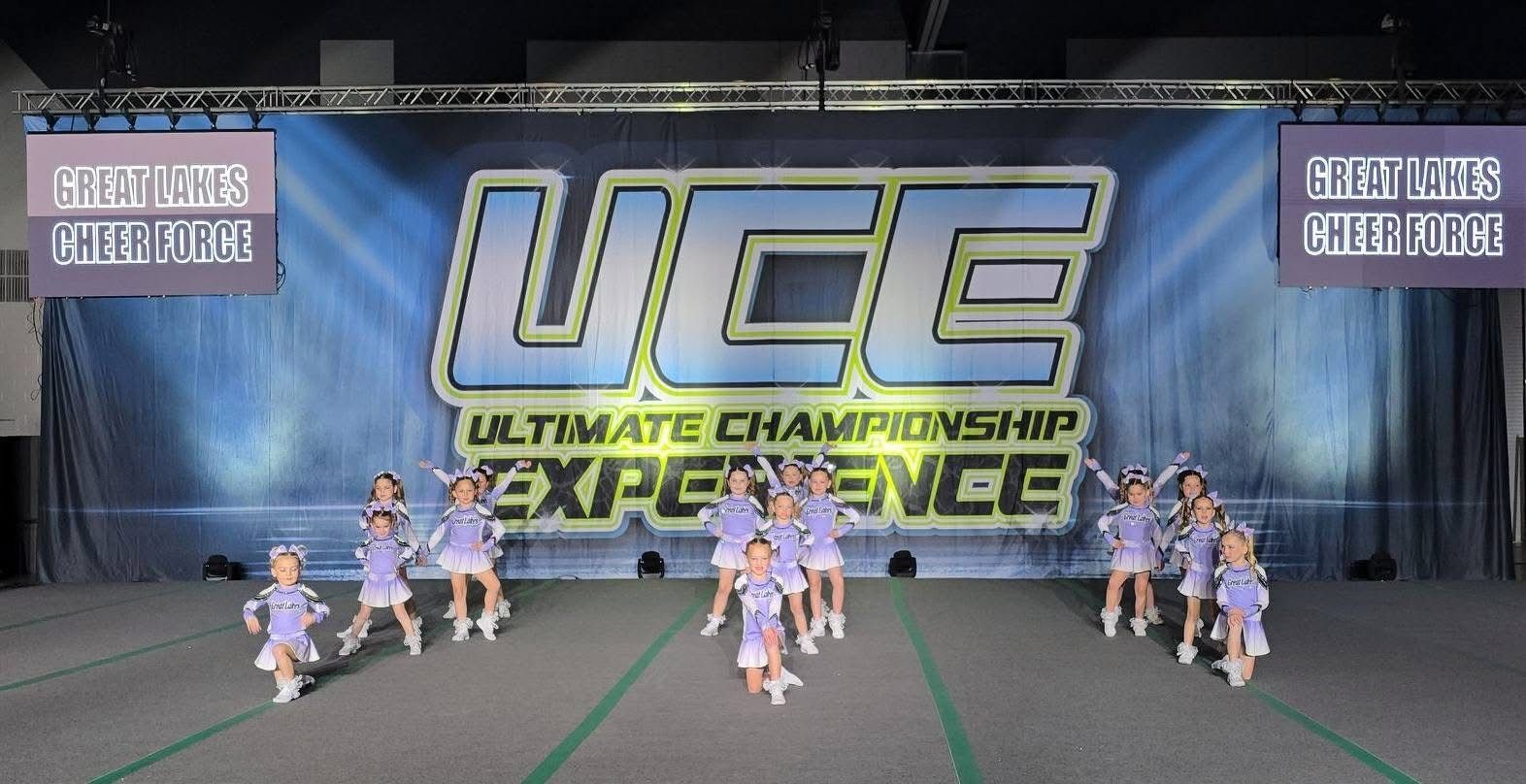 A group of cheerleaders are performing in front of a banner.