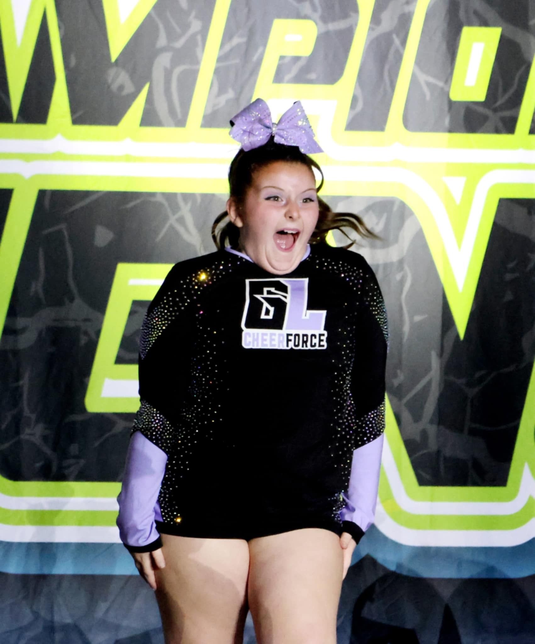 A girl wearing a black shirt with the letter l on it