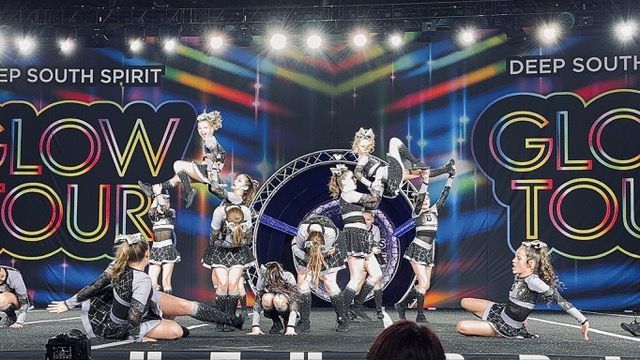 A group of cheerleaders are performing on a stage.