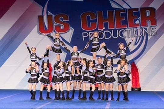 A group of cheerleaders are performing in front of us cheer productions