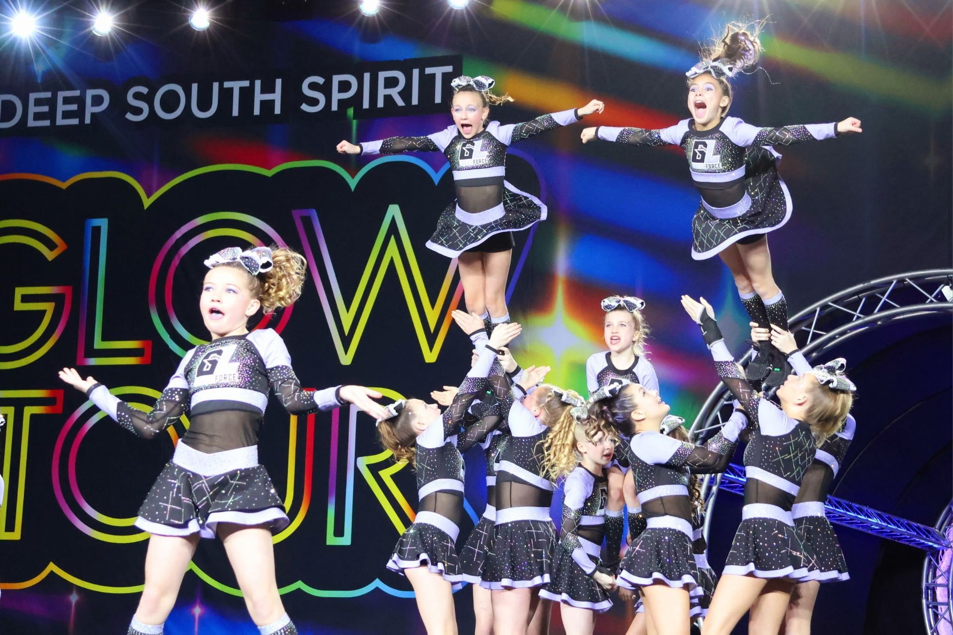 A group of cheerleaders are performing in front of a sign that says deep south spirit