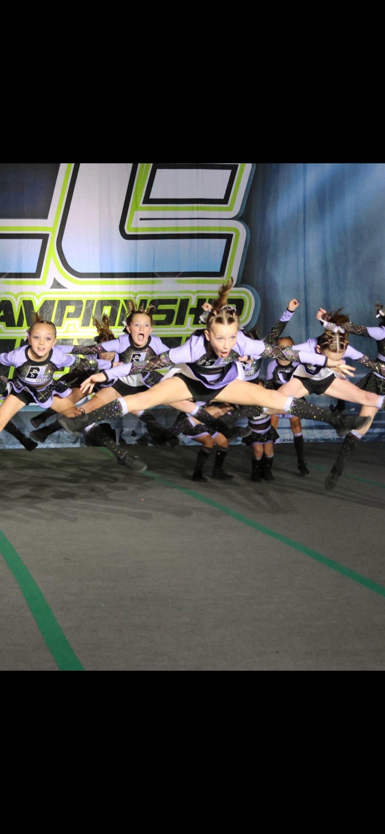 A group of cheerleaders are jumping in the air.