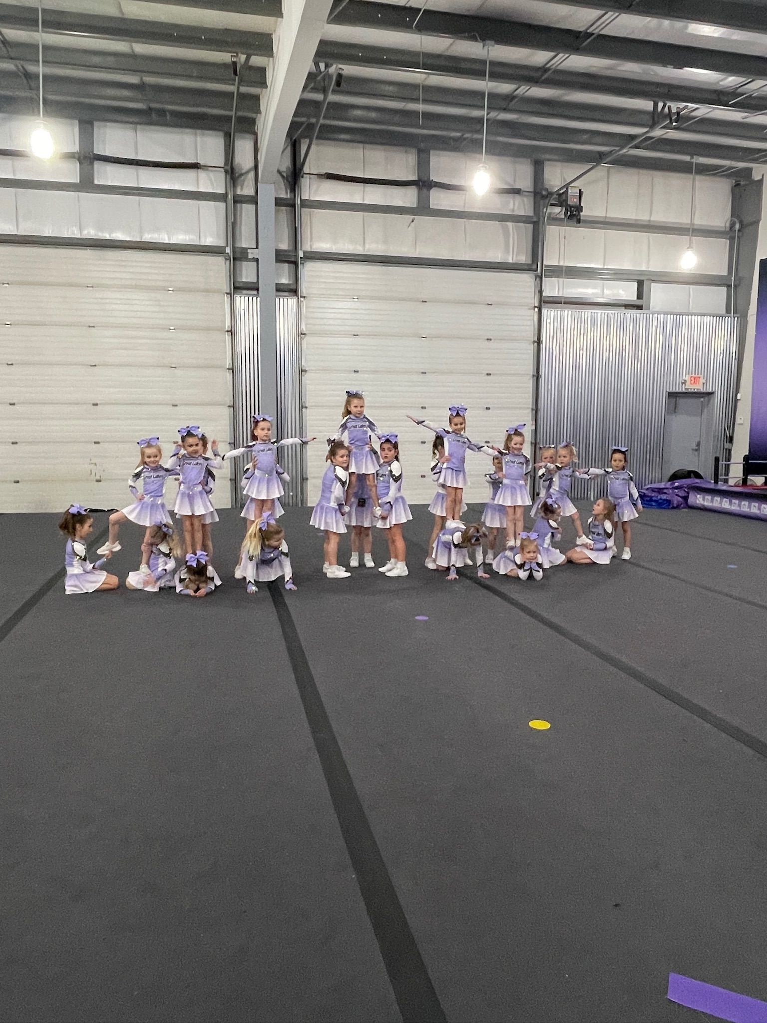 A group of cheerleaders are standing in a warehouse.