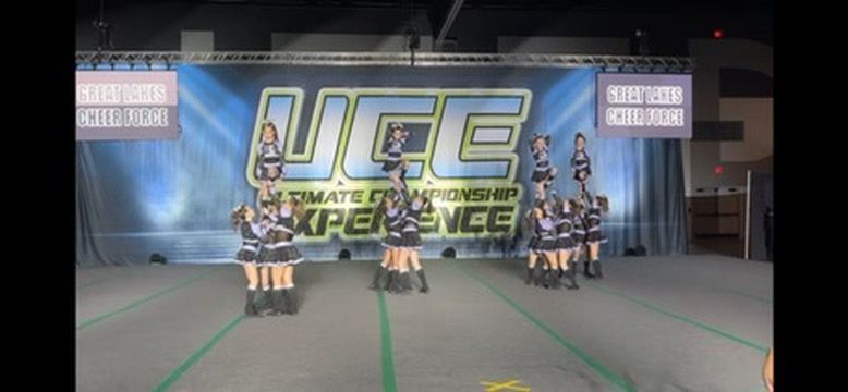A group of cheerleaders are performing in front of a banner that says ucsd experience