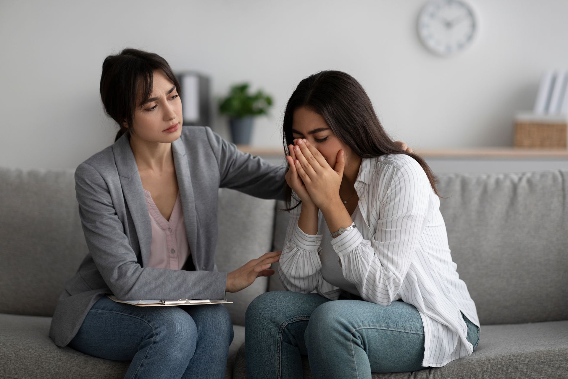 Woman Comforting Another Woman Who is Crying on a Couch — AT My Place Counselling and Psychotherapy in Neutral Bay, NSW