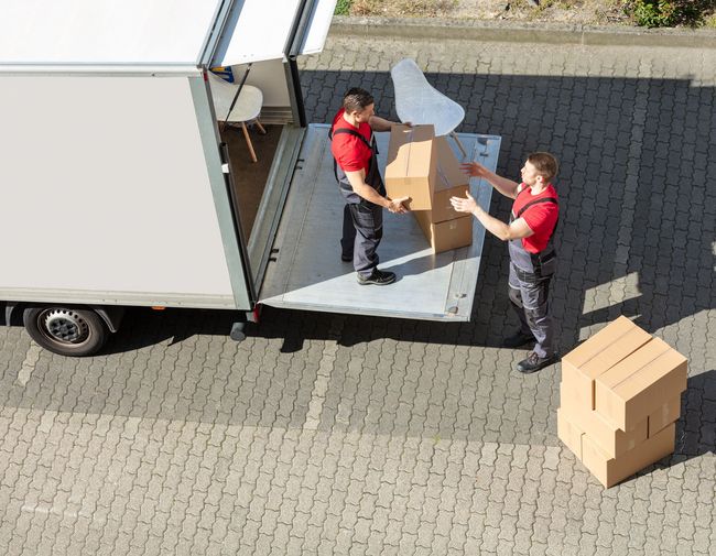 Two men are loading boxes into a truck.