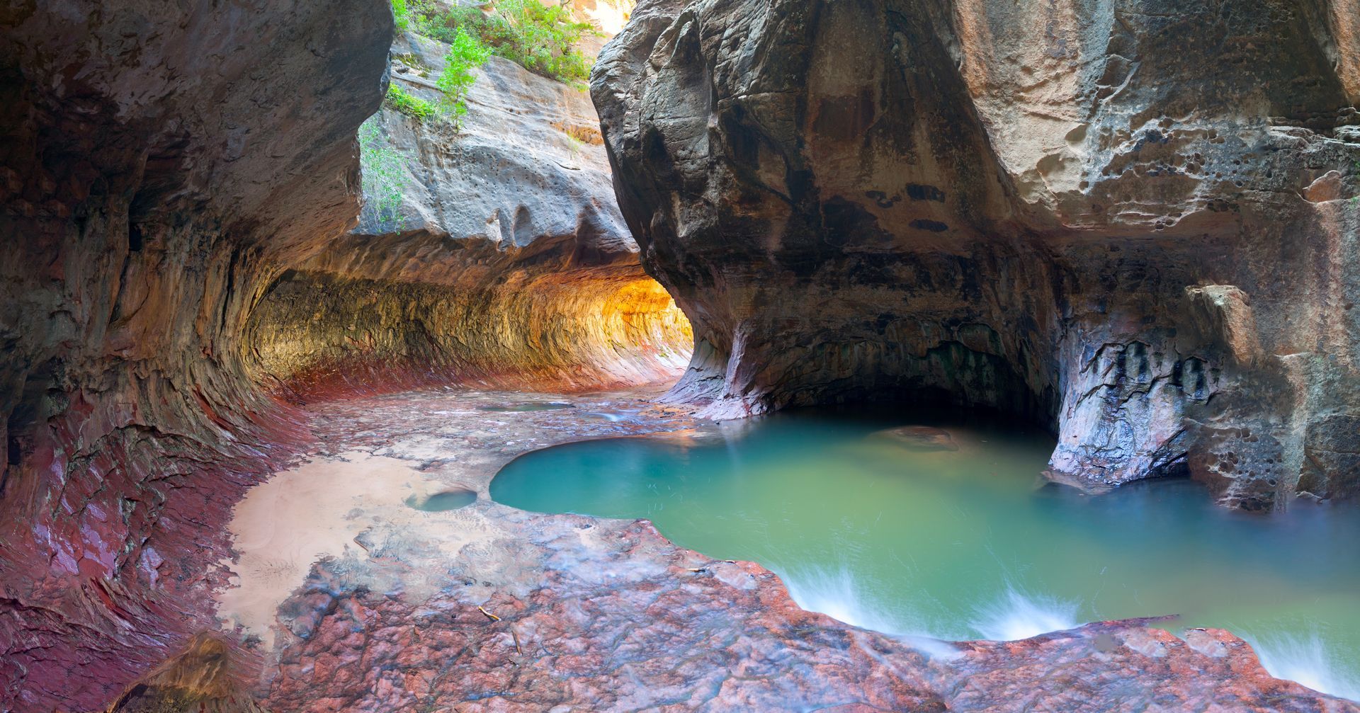 A cave with a pool of water in the middle of it.