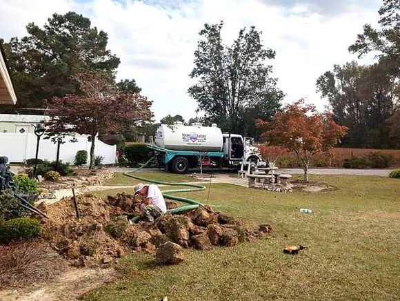 A septic tank is being installed in the backyard of a house.