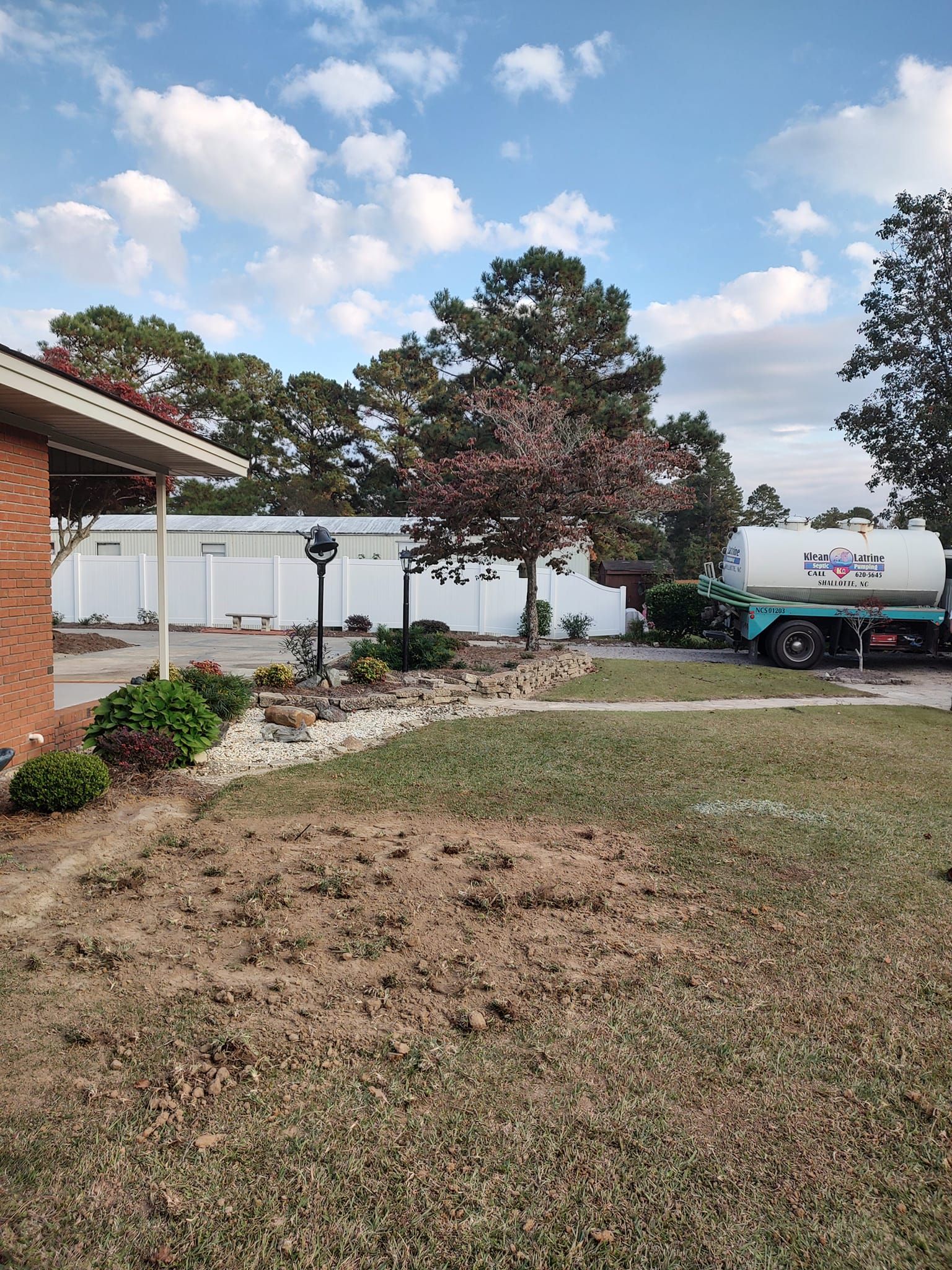 A tanker truck is parked in front of a house.