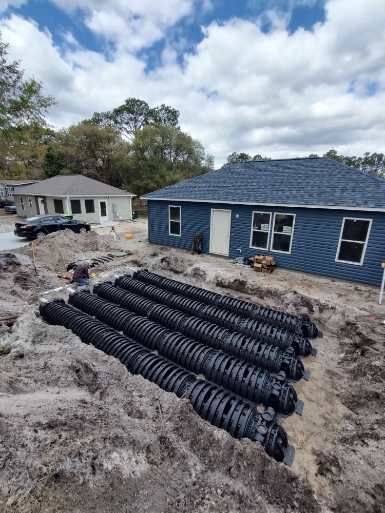 A septic system is being installed in front of a house.
