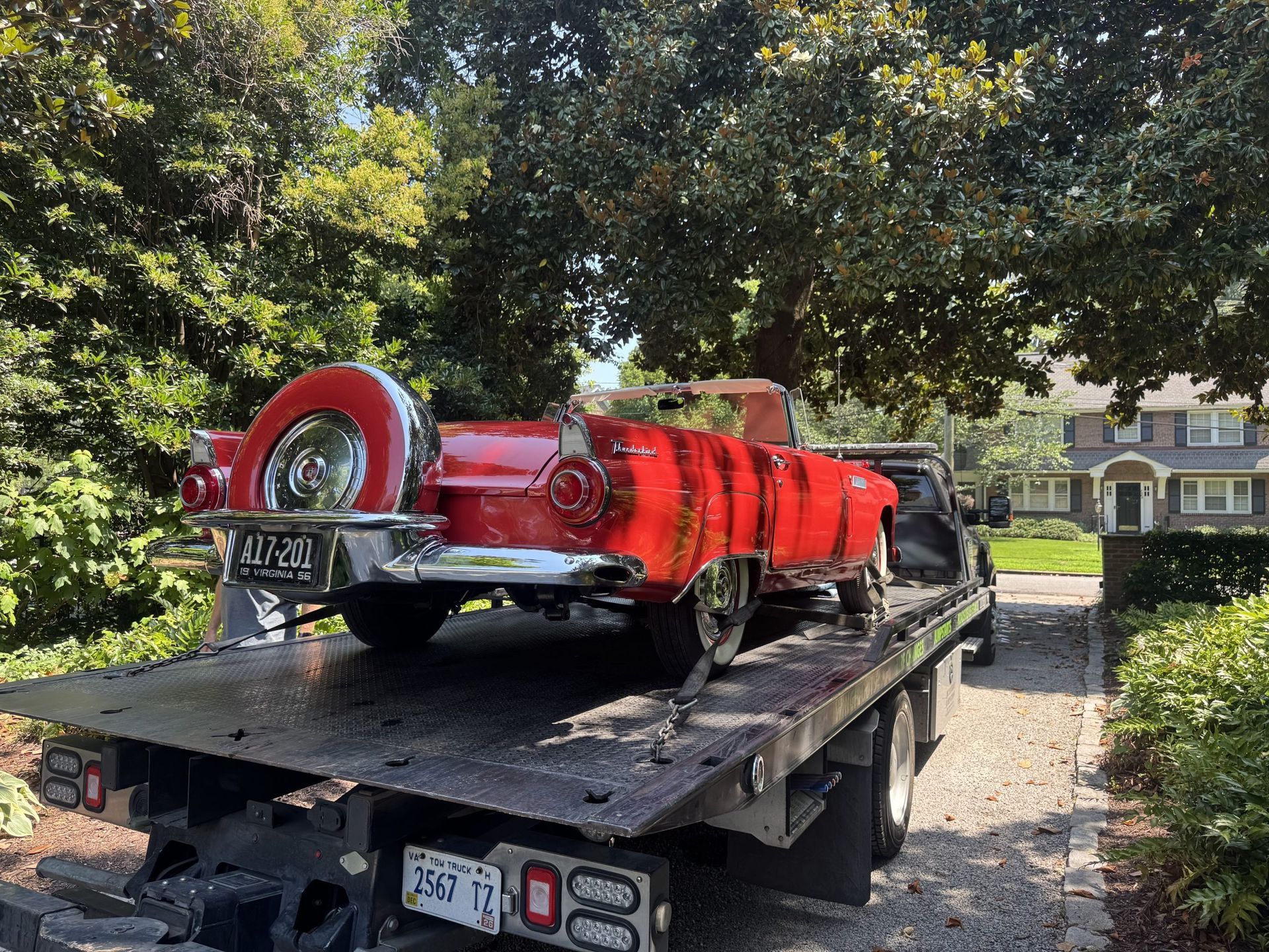 Red vintage car on a tow truck, license plate 
