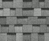 A close-up view of grey, textured architectural roofing shingles arranged in an overlapping pattern.