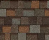 A textured pattern of multi-colored asphalt roofing shingles in shades of brown, gray, and rust.