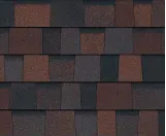 A pattern of rectangular asphalt roof shingles in blended shades of dark brown, reddish-brown, and charcoal gray.