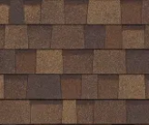 A close-up of brown, textured asphalt shingles with varied tones arranged in overlapping rows.