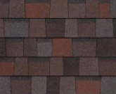 A repeating pattern of rectangular roof shingles in blended tones of dark brown, charcoal, and terracotta red.