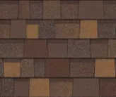 A close-up view of overlapping architectural asphalt roof shingles in varying shades of brown and tan.