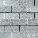 A close-up of a wall made of gray rectangular stone blocks arranged in a running bond pattern.