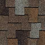 Close-up of overlapping asphalt roofing shingles in a textured mix of brown, tan, and grey tones.