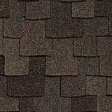 A close-up view of dark brown architectural asphalt roofing shingles arranged in an overlapping, staggered pattern.