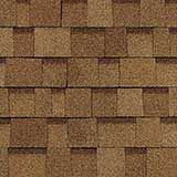 A close-up view of tan and brown architectural asphalt roofing shingles, showing a repeating, layered pattern.