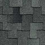 A close-up of dark grey asphalt roof shingles with a layered, rectangular overlapping pattern.