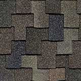 Close-up view of overlapping, multi-tonal brown and gray architectural roof shingles with a textured, layered pattern.